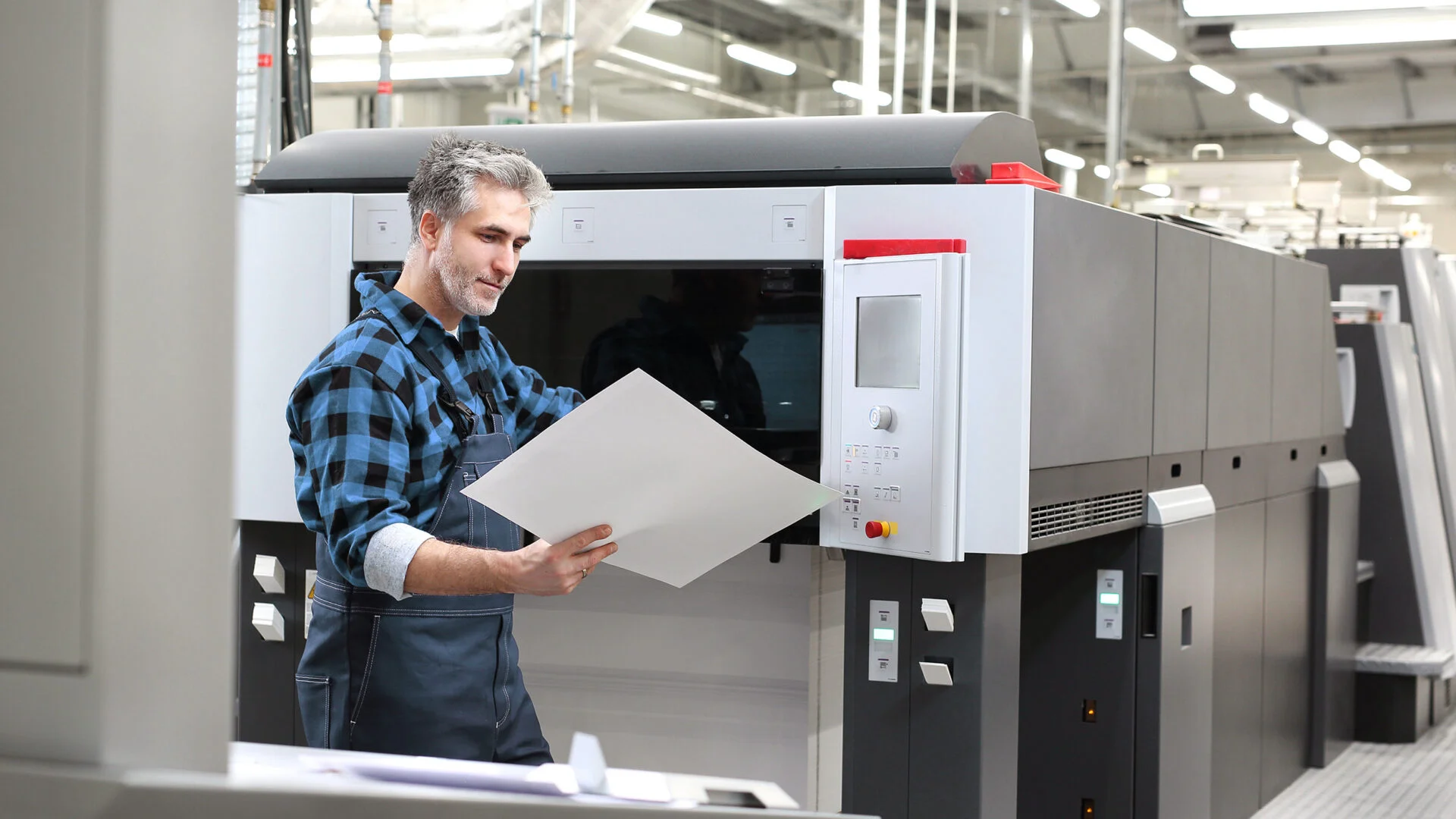 Drucktechniker überprüft das Ergebnis aus seiner Druckmaschine